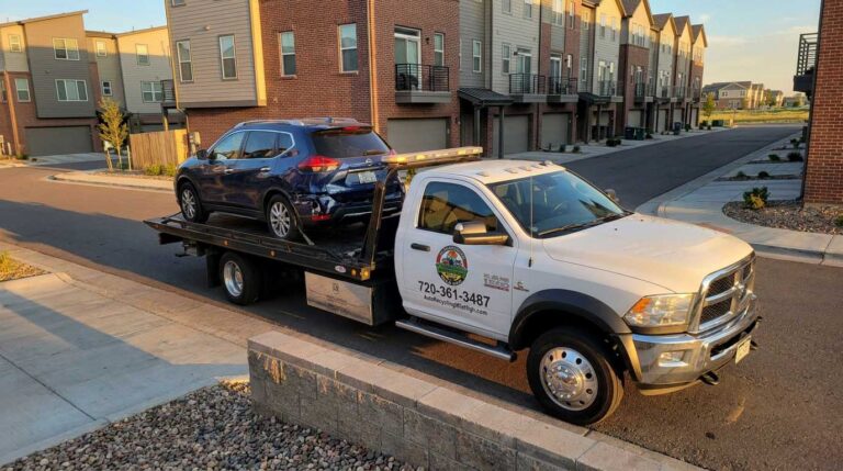 Dark blue 2018 Nissan Rogue loaded on an Auto Recycling Mile High tow truck at a cash-for-cars pickup in the Denver metro