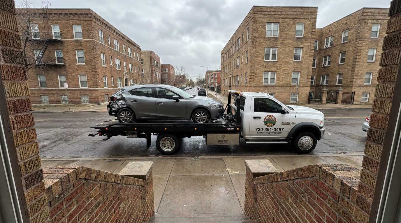 Gray 2016 mazda3 loaded on an Auto Recycling Mile High tow truck at a cash-for-cars pickup in the Denver metro