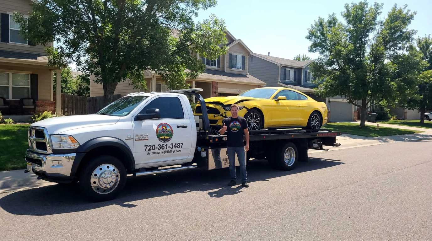 2016 Ford Mustang loaded on an Auto Recycling Mile High tow truck at a cash-for-cars pickup in the Denver metro