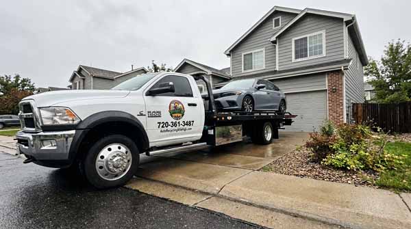 Gray 2025 Honda Civic on an Auto Recycling Mile High flatbed tow truck during a cash-for-cars pickup in Cherry Creek, Colorado